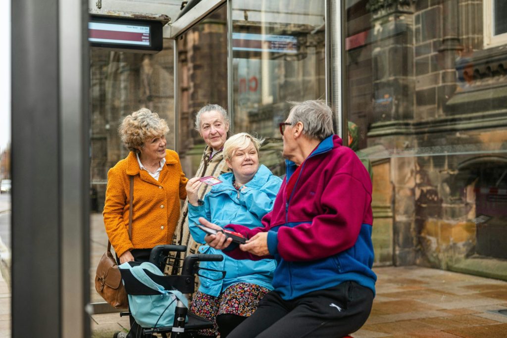 Elderly people talking at a bus stop